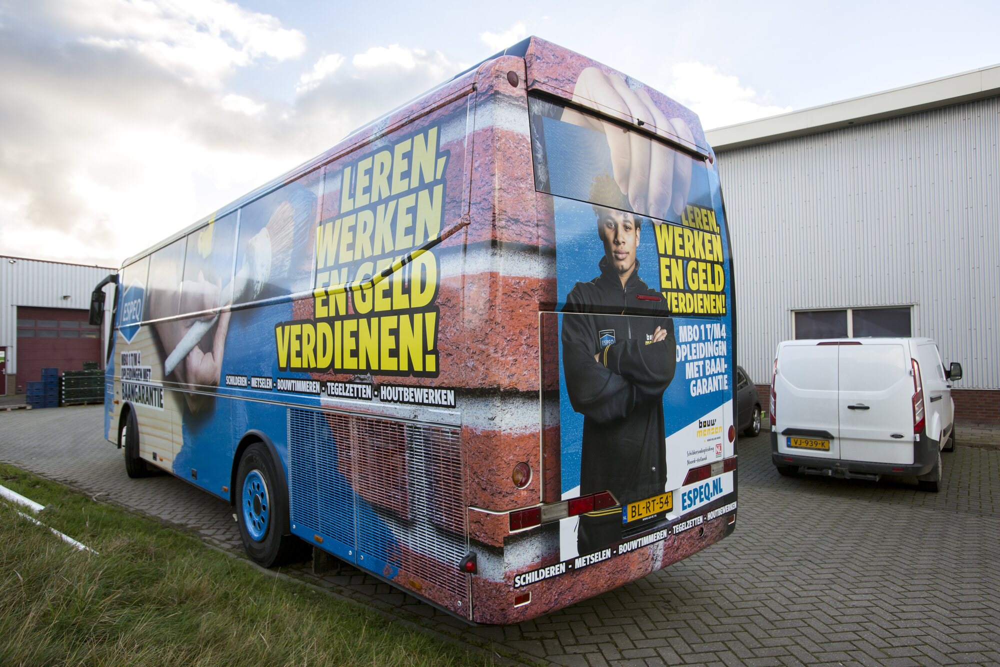 Ron van Noord — Visuele campagnes, DTP, Content + campagnes, Visual design — ESPEQ — promotiebus voor bouwopleidingen — Beeld: ESPEQ-promotiebus schuin van achteren aan de linkerzijde — Project: Een rijdende campagne die ESPEQ en de mogelijkheden van leren en werken in de bouw letterlijk zichtbaar maakt.