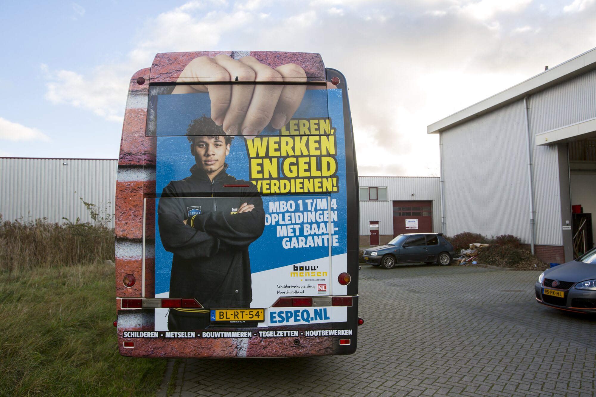 Ron van Noord — Visuele campagnes, DTP, Content + campagnes, Visual design — ESPEQ — promotiebus voor bouwopleidingen — Beeld: Achterzijde van de ESPEQ-promotiebus met leerling en opleidingsboodschap — Project: Een rijdende campagne die ESPEQ en de mogelijkheden van leren en werken in de bouw letterlijk zichtbaar maakt.